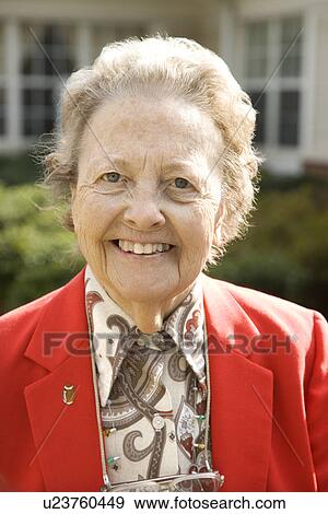 Stock Photo - Elderly Woman in Red Coat Outdoors Smiling. Fotosearch