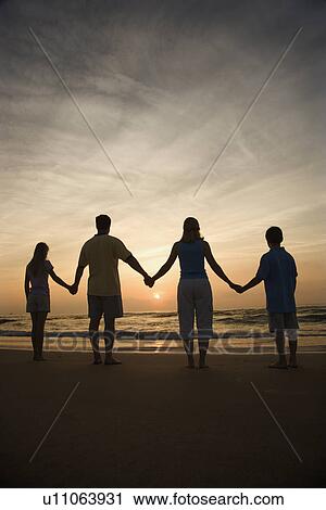 Stock Image - Family Holding Hands on Beach. Fotosearch