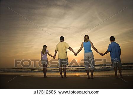 Stock Photography - Family holding hands on beach. Fotosearch