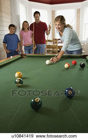 Stock Photo - Family Playing Pool in Rec Room. Fotosearch