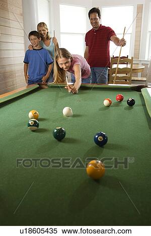 Stock Photography - Family Playing Pool in Rec Room. Fotosearch