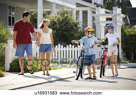 Stock Image - Family Walking with Bicycles. Fotosearch