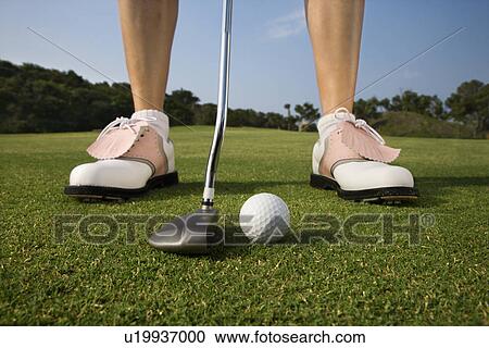 Stock Image - Female Golfer Putting. Fotosearch