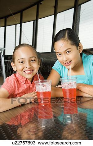 Girls Sitting and Smiling with Drinks View Large Photo Image Stock Image - Girls Sitting and Smiling with Drinks. Fotosearch