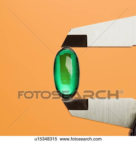 Stock Photography - Green Capsule in Caliper. Fotosearch