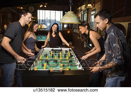 Stock Image - Group of People Playing Foosball. Fotosearch