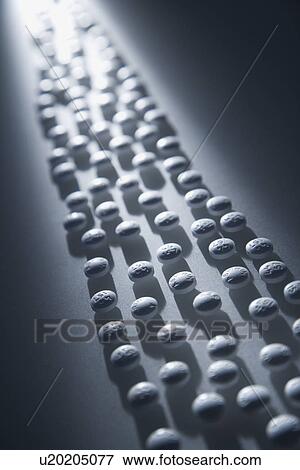 Stock Photo - Lined Up White Pills. Fotosearch
