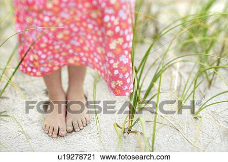 Stock Image - Little Girls Feet in the Sand. Fotosearch