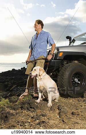 Picture - Man and Dog by SUV at the Beach. Fotosearch