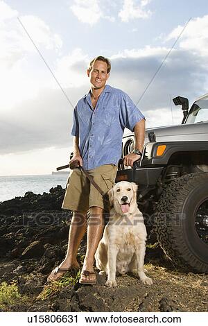 Stock Image - Man and Dog by SUV at the Beach. Fotosearch