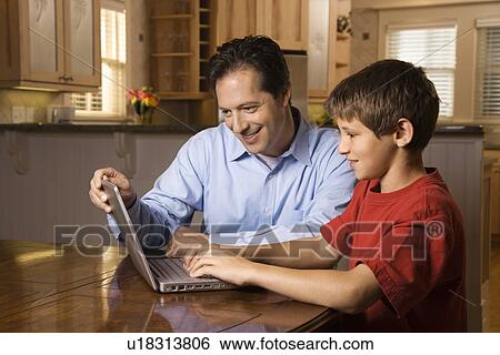 Stock Photograph - Man and Young Boy on Laptop. Fotosearch