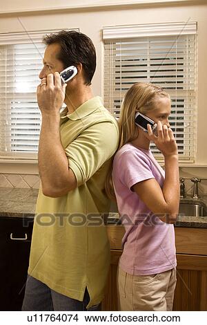 Picture - Man and Young Girl on Phones. Fotosearch