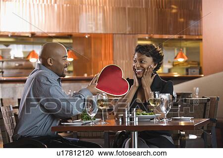Man Giving Woman Heart Shaped Box at Restaurant View Large Photo Image Stock Image - Man Giving Woman Heart Shaped Box at Restaurant. Fotosearch