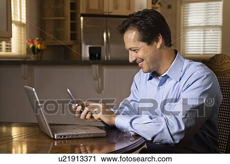 Stock Image - Man with Cell Phone and Laptop. Fotosearch