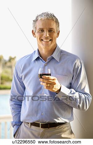 Stock Image - Middle Aged Man Drinking Wine. Fotosearch