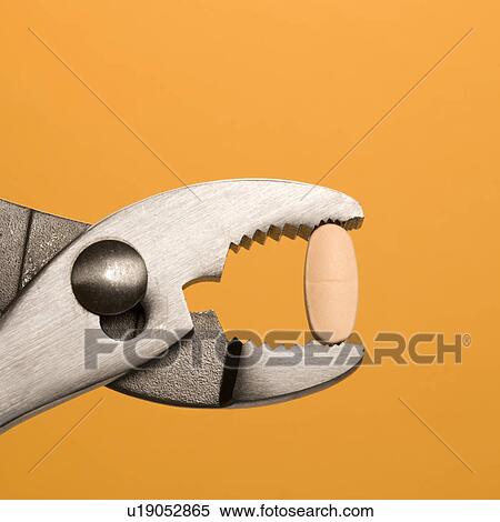 Stock Photography - Pill Gripped With Pliers. Fotosearch