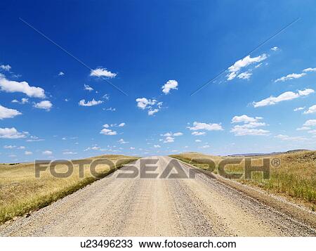 Stock Image - Rural Dirt Road Through Grassland. Fotosearch