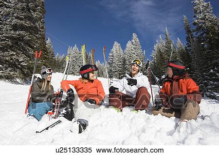 Stock Photography - Skiers Sitting in Snow Talking. Fotosearch