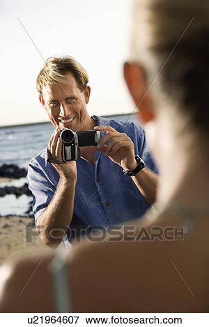 Smiling Man Filming Woman At Beach View Large Photo Image Stock Photo - Smiling Man Filming Woman At Beach. Fotosearch