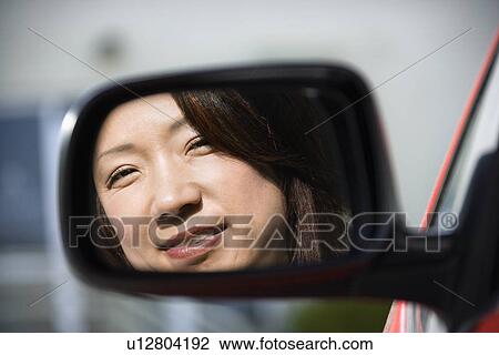 Smiling woman in car mirror View Large Photo Image Stock Image - Smiling woman in car mirror. Fotosearch