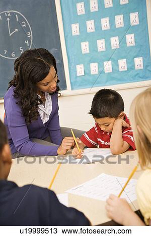 Stock Image - Teacher Helping Student. Fotosearch