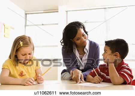 Stock Image - Teacher Helping Students With Schoolwork . Fotosearch