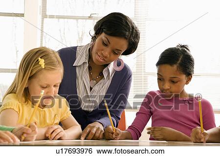 Teacher Helping Students With Schoolwork View Large Photo Image Stock Photograph - Teacher Helping Students With Schoolwork . Fotosearch