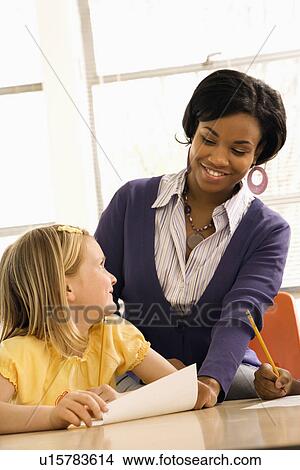 Teacher Smiling and Helping Students With Schoolwork View Large Photo Image Picture - Teacher Smiling and Helping Students With Schoolwork . Fotosearch
