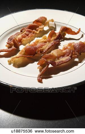 Stock Photograph - Three Strips of Cooked Bacon on White Plate. Fotosearch