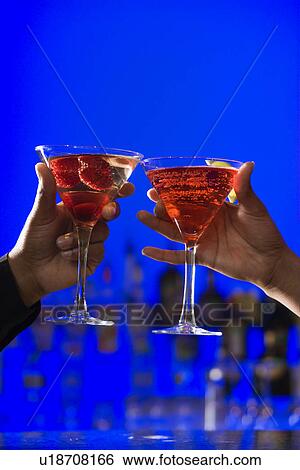 Stock Photograph - Toasting Cocktails in Martini Glasses. Fotosearch
