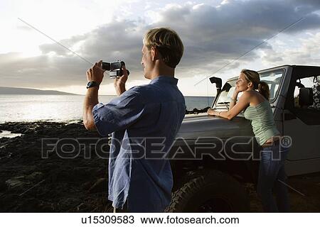 Tourist Couple Enjoying a Beach Sunset View Large Photo Image Stock Image - Tourist Couple Enjoying a Beach Sunset. Fotosearch