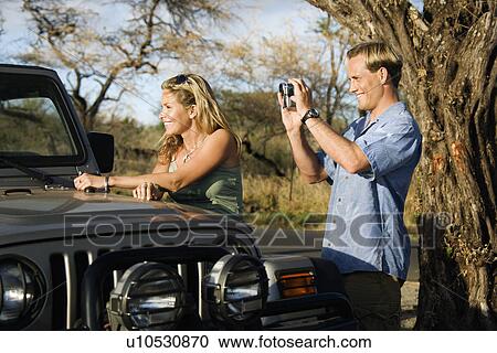 Tourist Couple Standing By Car View Large Photo Image Stock Image - Tourist Couple Standing By Car. Fotosearch
