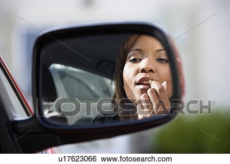 Woman applying lipstick View Large Photo Image Stock Photograph - Woman applying lipstick. Fotosearch
