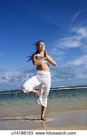 Stock Image - Woman Doing Yoga on Beach. Fotosearch