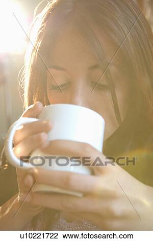 Stock Image - Woman drinking from mug. Fotosearch