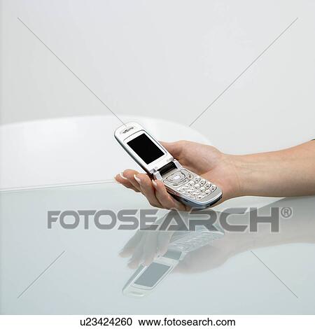 Stock Image - Woman holding cellphone. Fotosearch
