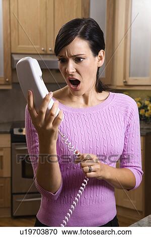 Woman holding phone in disbelief View Large Photo Image Stock Image - Woman holding phone in disbelief. Fotosearch
