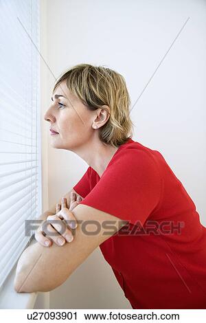 Stock Image - Woman looking out window.. Fotosearch