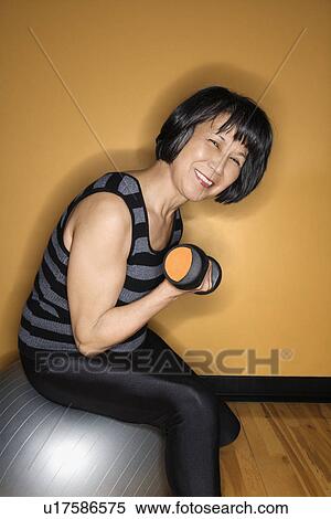Stock Photography - Woman on Balance Ball Lifting Weights. Fotosearch