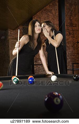 Stock Photo - Woman whispering to woman.. Fotosearch