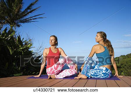 Stock Image - Women Doing Yoga Outdoors. Fotosearch