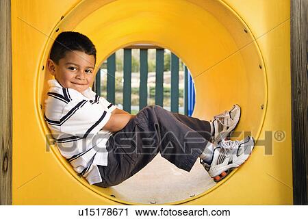 Stock Image - Young Boy Lying in Crawl Tube. Fotosearch