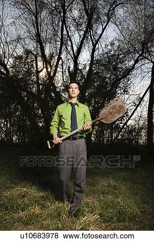 Stock Photo - Young Businessman Holding Shovel. Fotosearch