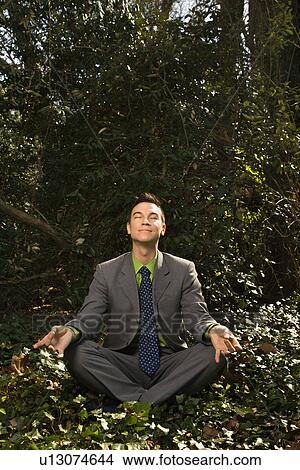 Picture - Young Businessman Sitting in Meditation. Fotosearch