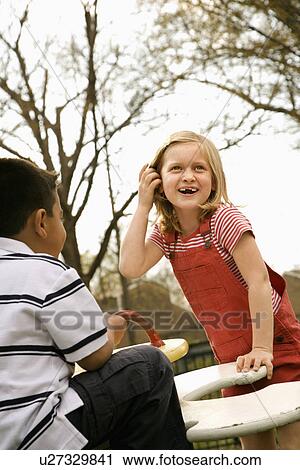 Stock Image - Young Girl and Boy Playing on Playground. Fotosearch