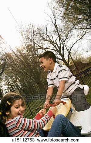 Young Girl and Boy Playing on Seesaw View Large Photo Image Stock Image - Young Girl and Boy Playing on Seesaw. Fotosearch
