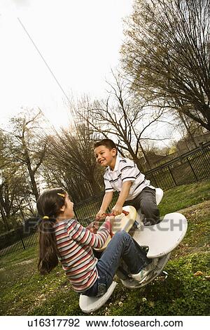 Young Girl and Boy Playing on Seesaw View Large Photo Image Stock Image - Young Girl and Boy Playing on Seesaw. Fotosearch