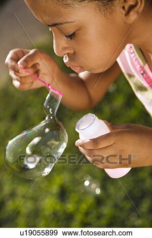 Stock Photo - Young Girl Blowing Bubbles. Fotosearch