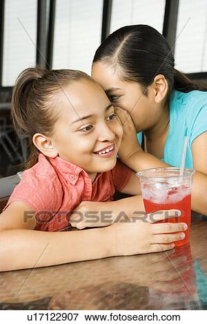 Stock Photo - Young Girl Whispering to Another. Fotosearch