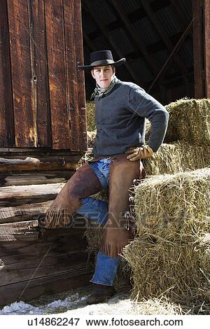 Stock Photo - Young Man Leaning on Hay Bales. Fotosearch